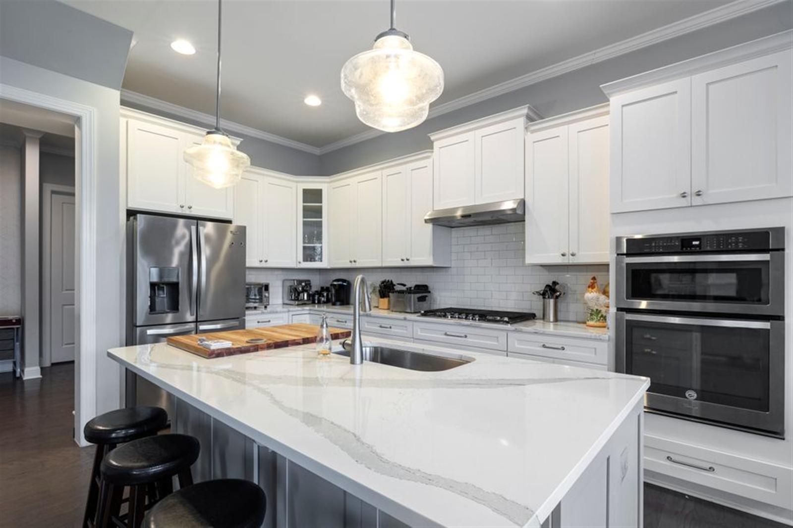 Contemporary kitchen with marble island and stainless steel appliances and faucet