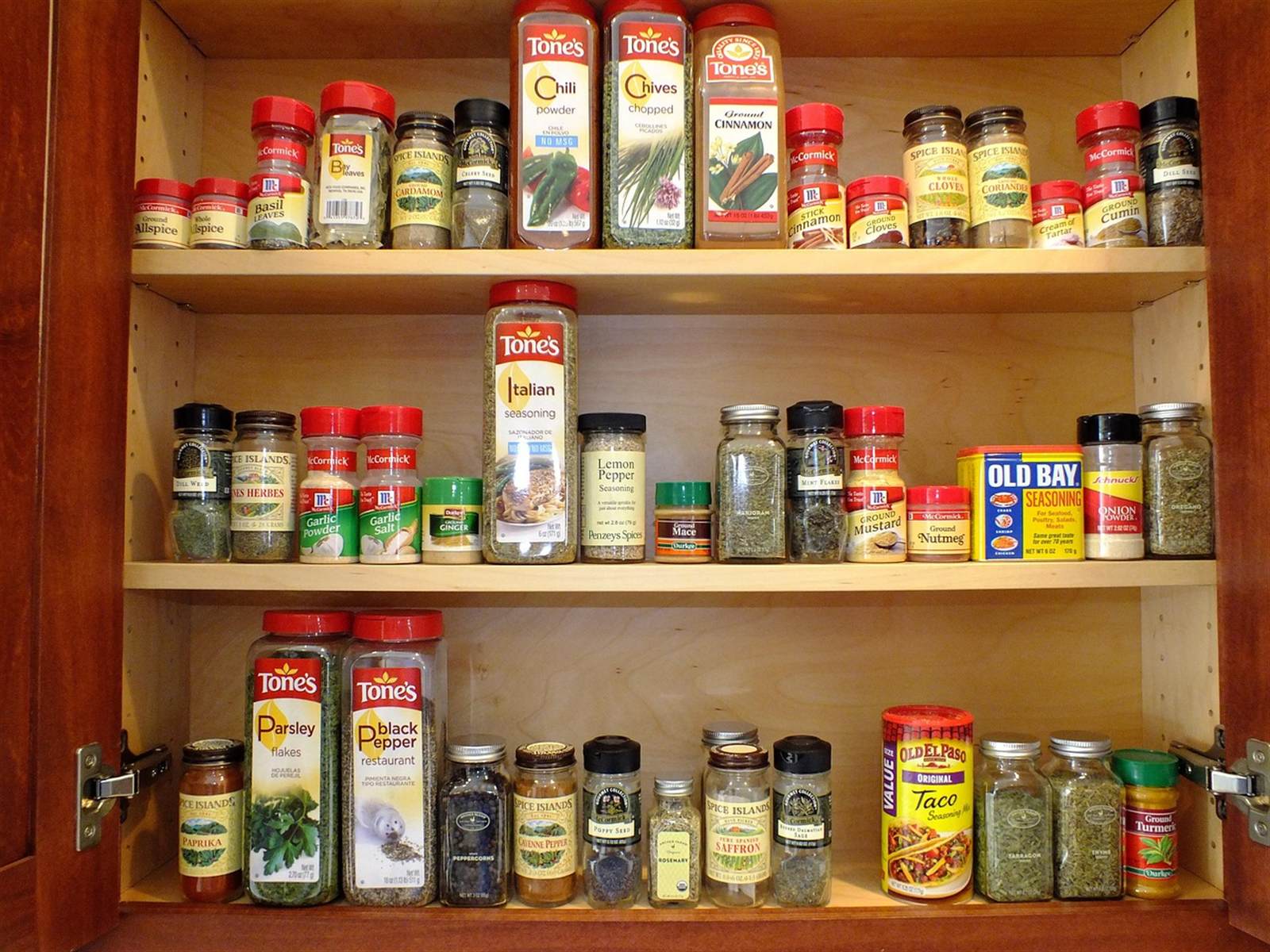 Neatly organized kitchen cabinet with labeled spice jars showing beautiful, functional storage