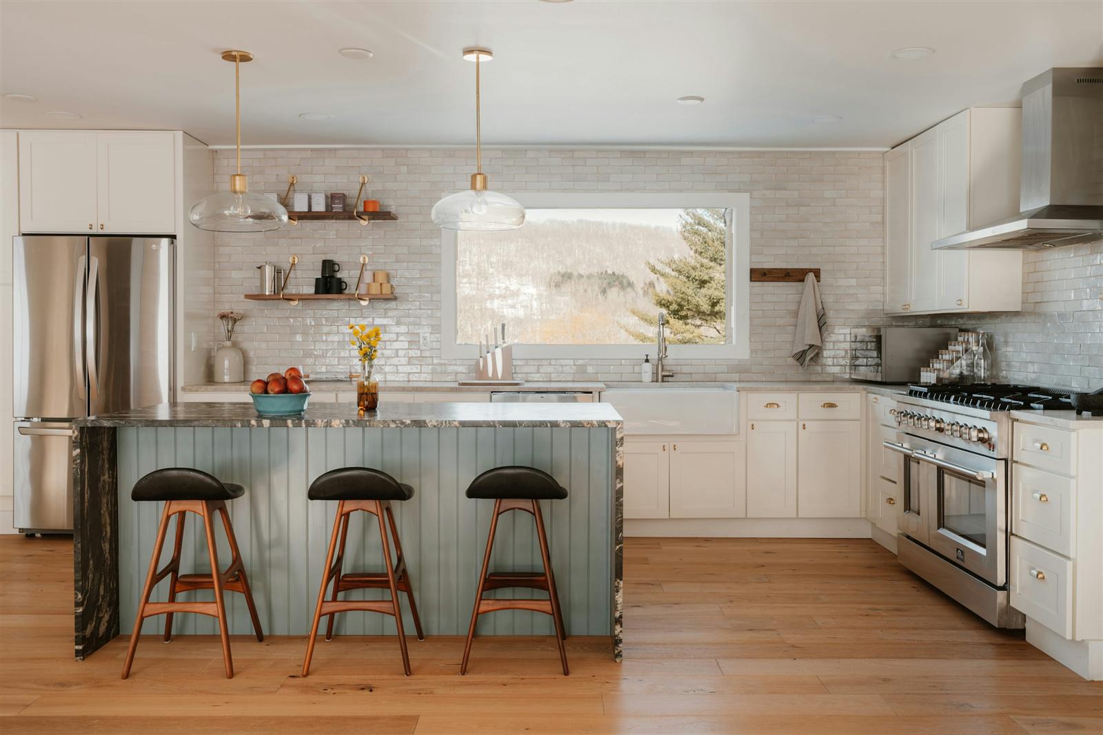 A modern kitchen with a large island and stainless steel appliances, showing the extra workspace an island adds