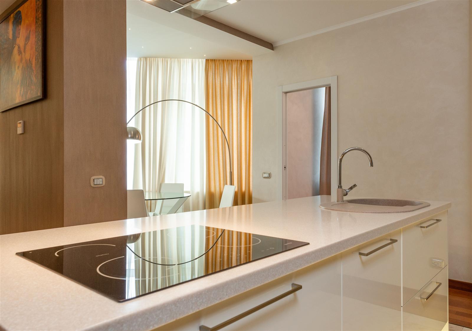 A modern kitchen island with a built-in stove and sink, demonstrating added appliance capacity and storage