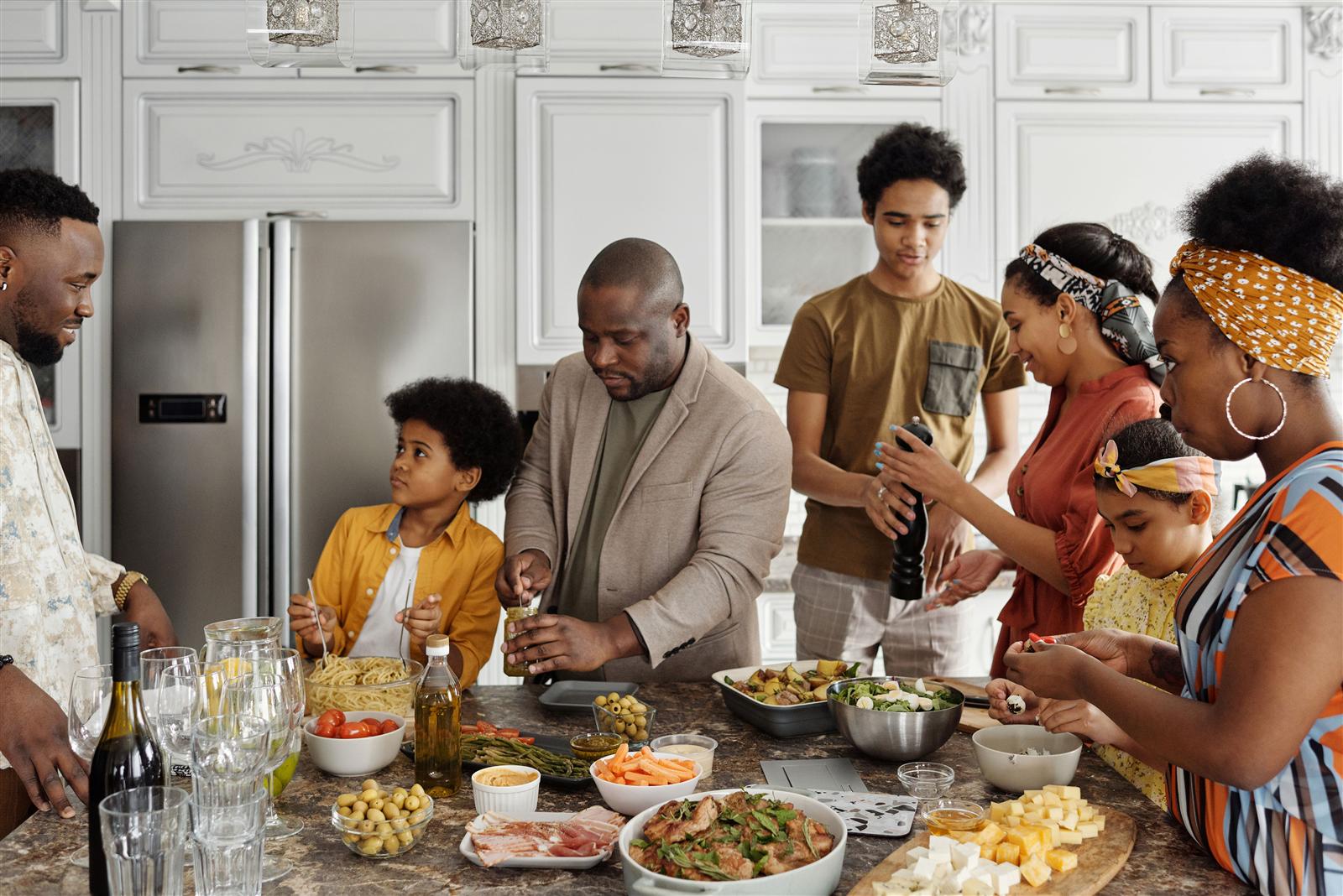 A family preparing food together at a kitchen island, illustrating the social and multi-generational cooking benefit of an island