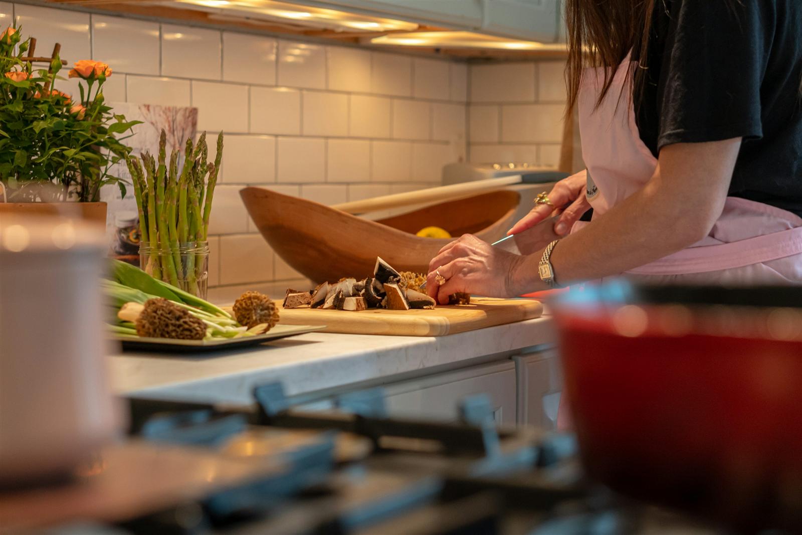 A person chopping vegetables at a kitchen island counter, showing the extra food-prep workspace an island provides