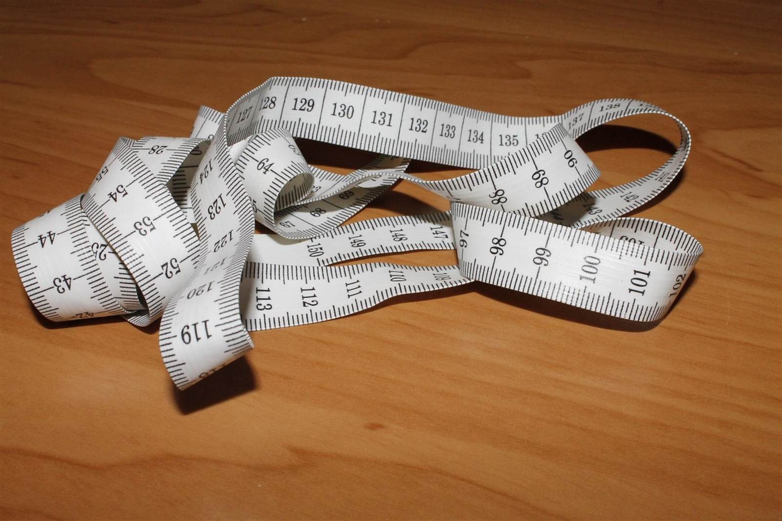 A coiled yellow tape measure, the essential tool for measuring cabinet pull hardware accurately