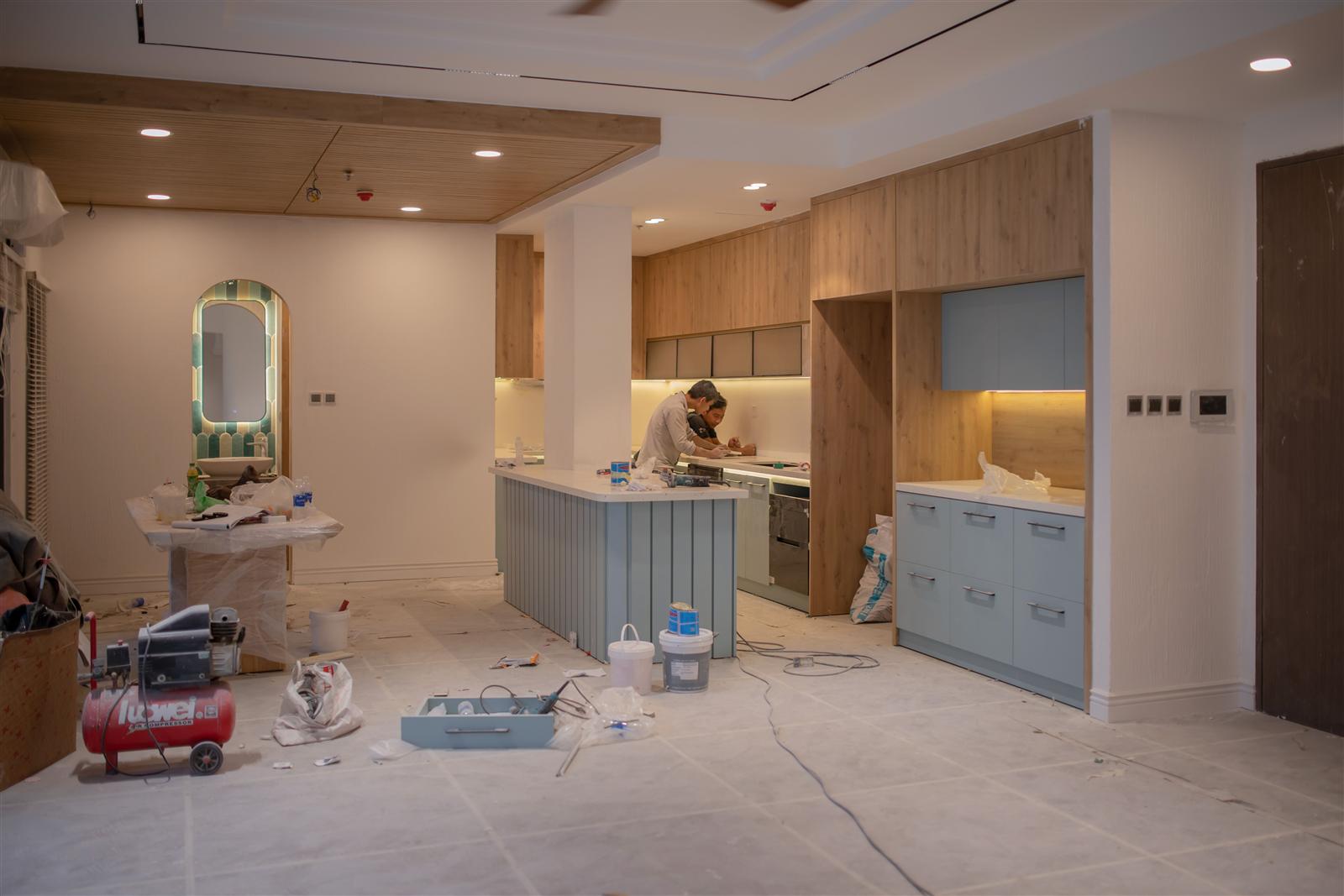 Contractor working in a modern kitchen mid-renovation surrounded by tools and materials