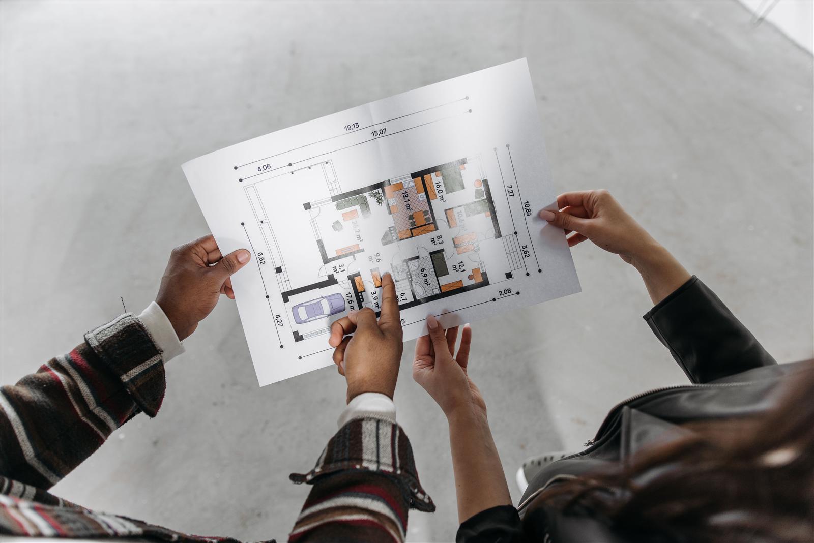 Couple reviewing architectural blueprints together while planning a home renovation